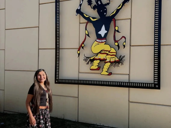 student posing in front of Native American Art picture